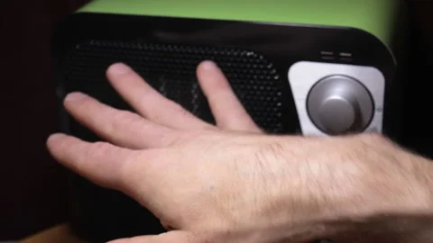 Frozen hands warming near electric heater in cold house. Seasonal problem Video stock 213935676