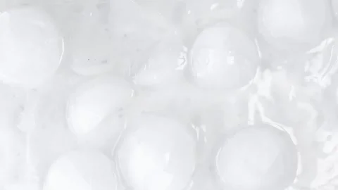 Frozen ice blocks immersed in splashing water creating dramatic jets. Cold cryst Stock Footage 332850811