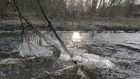 Frozen Ice on Branches, Sun Reflection and Fast Flowing River Stock Footage 101683490