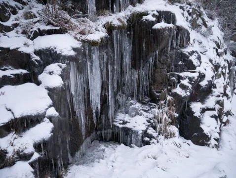Frozen ice hanging down from the mountain side Stock Photos