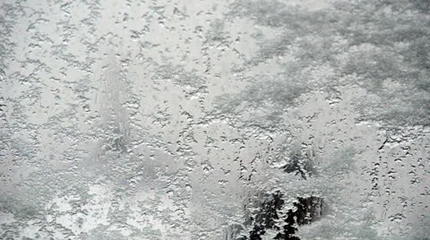 Frozen ice melting on window Stock Footage