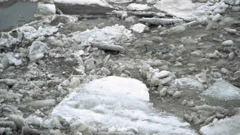 Frozen ice river is melting in spring with ice flakes flowing. Cracked ice Stock Footage 88730765