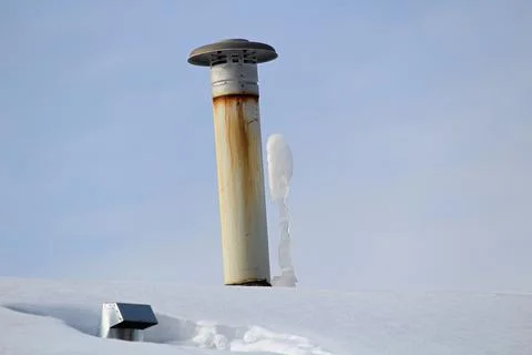 Frozen icicles beside a chimney stack in winter Stock Photos