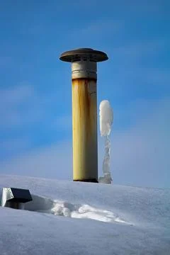 Frozen icicles beside a chimney stack in winter Stock Photos