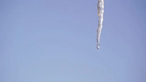 Frozen icicles isolated on blue sky background on a sunny spring day Stock Footage 158827588