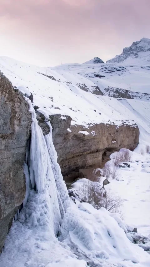 Frozen icy Bæjarfoss waterfall with icicles in Iceland (Aerial View) Stock Footage 304236212