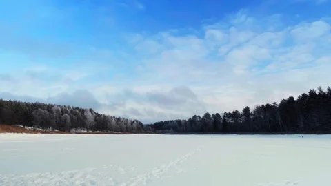 Frozen lake covered with snow with a pine forest in the background. Sunny day. Stock-Footage 123073282