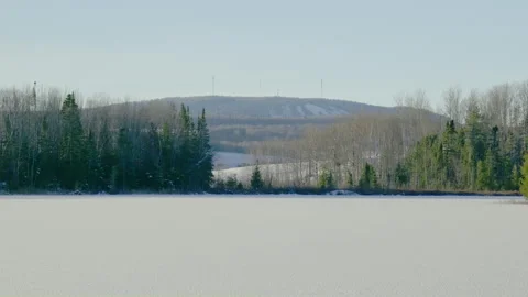 Frozen lake forest valley with background ski mountain with transmission Stock Footage 256020122