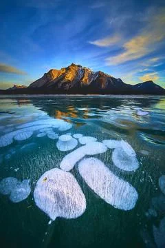 Frozen Lake Methane Bubbles and Mountain Peaks Under Winter Sky Stock Photos