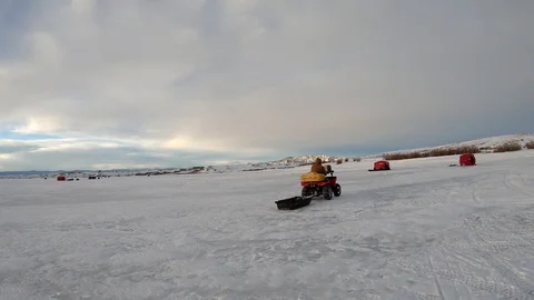 Frozen lake quad pulling sled in winter during winter polar vortex 4k Stock Footage 102241890