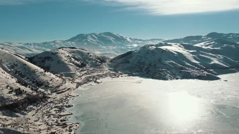 Frozen Lake, Snowy Range Mountains, Snowy vegetation, roads. Aerial View. Video stock 236795977