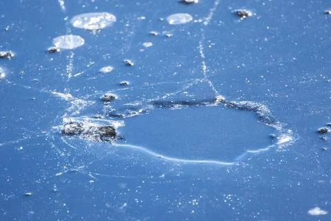 Frozen lake surface with a hole in thin ice, natural background photo Stock Photos