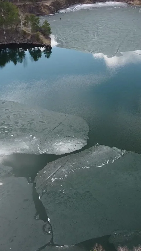 Frozen lake surface reflects sky and trees Stockbeeldmateriaal 347499569