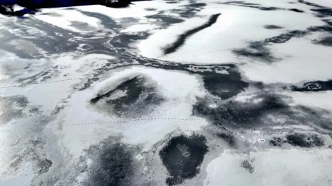 Frozen lake surface with textured ice patches and reflected light in winter – Stock Footage 308522517