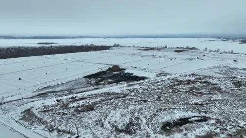 Frozen landscape spreads beneath thick dark cloud cover Stock Footage 327801906