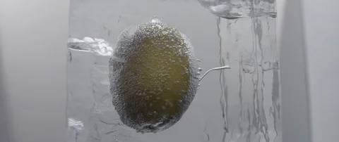 A frozen lemon rotates in an ice cube on white background. Stock Footage 106006712