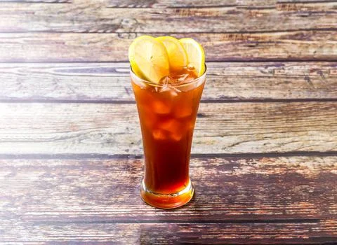Frozen Lemon Tea topped with lime slice and ice cube served in glass isolat.. Stock Photos