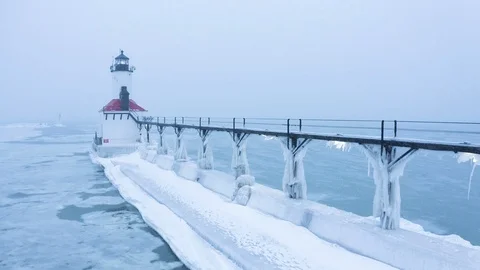 Frozen Lighthouse on Lake Michigan Snowing Push - 4K Aerial Video stock 113687322