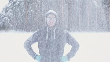 A frozen man posing in a winter forest during a snowfall smiling Stock Footage 85578621