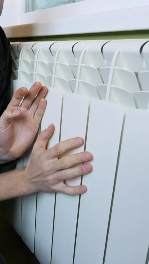 Frozen Man Warming Cold Hands On White Central Heating Radiator Stock Footage 329403090