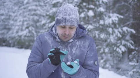 Frozen man in the winter forest uses the phone Stock Photos