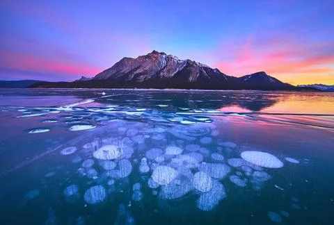 Frozen Methane Ice Bubbles Sunset Reflection and Winter Mountains Landscape Stock Photos