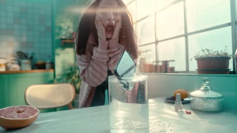 Frozen Moment capturing phone dropping into glass of water Stock Footage 274955122