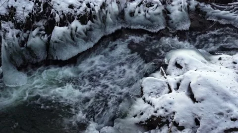 Frozen mountain river flowing through icy rocks and snow Stock Footage 149553161