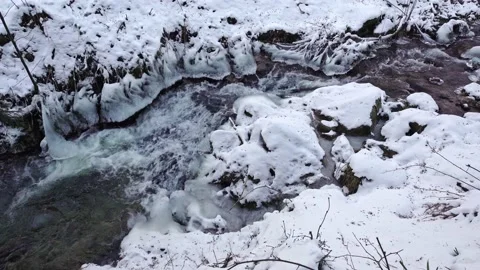 Frozen mountain river flowing through icy rocks and snow Stock Footage 149553479