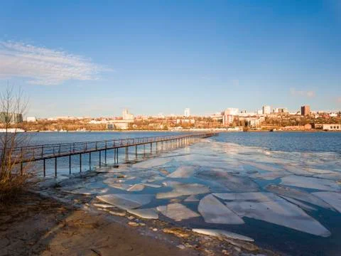 Frozen old pier at river side in winter time. Stock Photos