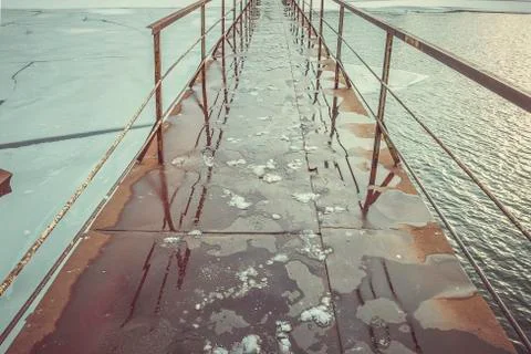 Frozen old pier at river side in winter time. Foto stock