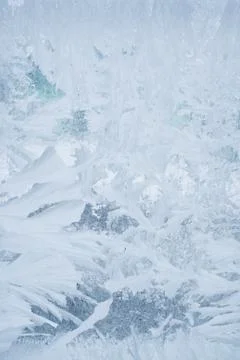 Frozen pattern on the window glass in the winter and tinted in blue Stock Photos