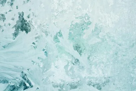 Frozen pattern on the window glass in the winter and tinted in emerald Stock Photos