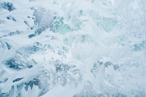Frozen pattern on the window glass in the winter and tinted in blue Stock Photos