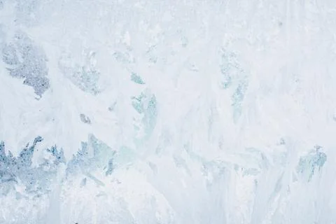 Frozen pattern on the window glass in the winter and tinted in blue Stock Photos