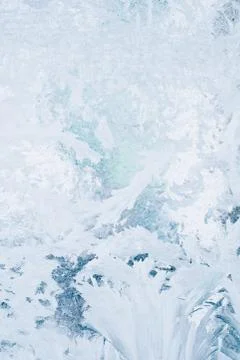 Frozen pattern on the window glass in the winter and tinted in blue Stock Photos