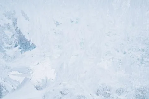 Frozen pattern on the window glass in the winter and tinted in blue Stock Photos