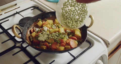 Frozen peas are being added to a delicious mix of potatoes and carrots Stock Footage 158431355
