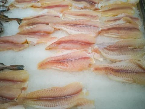 Frozen pieces of delicious fish fillet among ice in a hypermarket Stock Photos