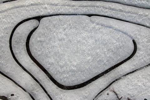 Frozen puddle with spacious circular air cavities Stock Photos