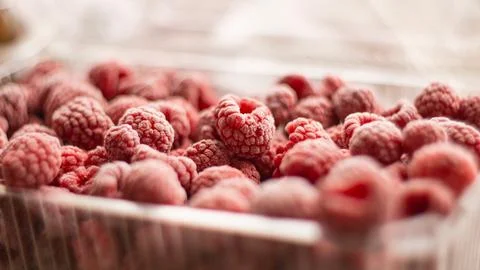 Frozen raspberries inside Plastic container. healthcare, healthy food concept Stock Photos