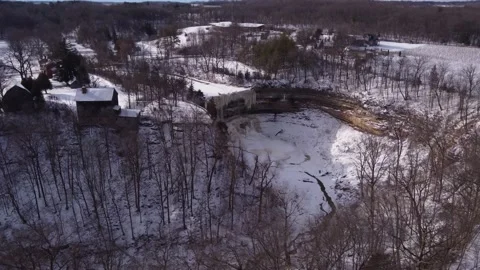 Frozen ravine and waterfall next to century old home Stock Footage 228470646
