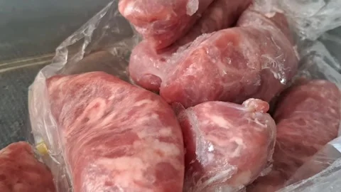 Frozen raw sausages packed in clear plastic motion video footage Stock Footage 339248213