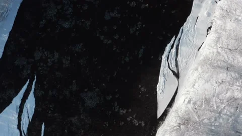 A frozen river flows between the trees covered with white snow. Stock-Footage 169563467