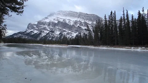Frozen river at the foot of a mountain in Alberta Stock Footage 90829239