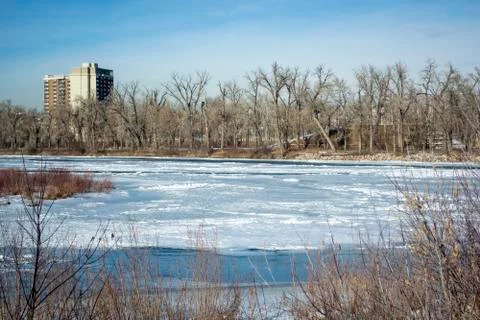 Frozen River Iced Over With Trees Lining Edges Foto stock