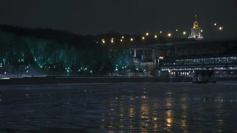 Frozen river. Illuminated forest at winter night. Moscow State University. Luzhn Stockbeeldmateriaal 104341016