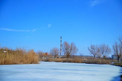 Frozen river landscape under clear blue sky Stock Photos