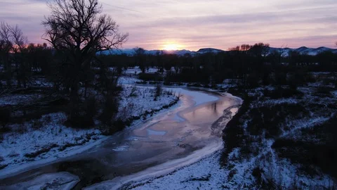 Frozen river in the snow covered landscape at sunset 動画素材 91982508
