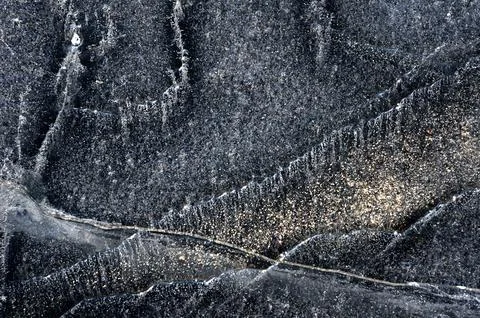 Frozen river. Sun rays on ice. Silver ice texture. Stock Photos